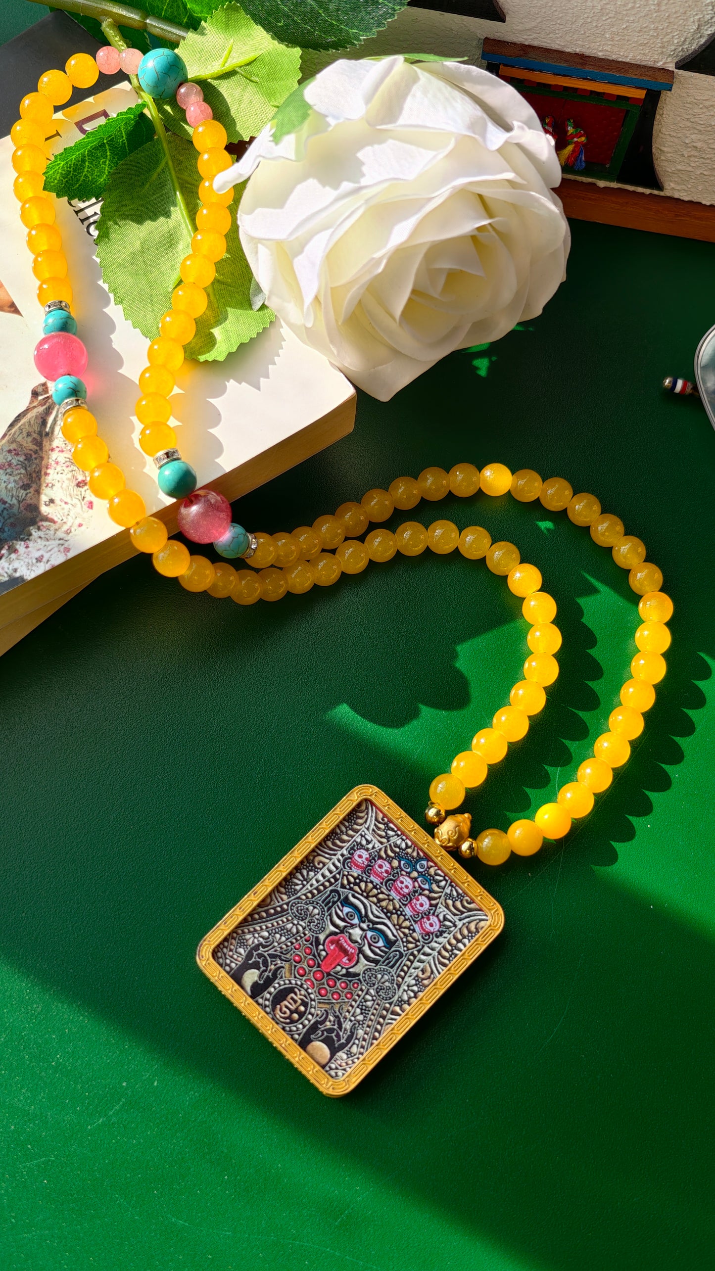 Necklace with amber beads and a hand-painted thangka pendant