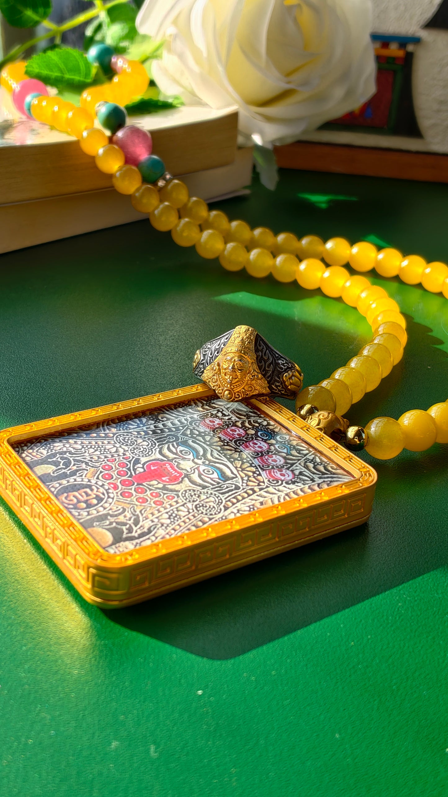 Necklace with amber beads and a hand-painted thangka pendant